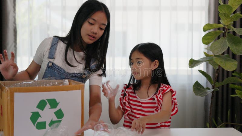 Asian little Girls dump plastic bottles in recycling boxes to reduce trash, reuse, and recycle. Recyclability and sustainability stock photos