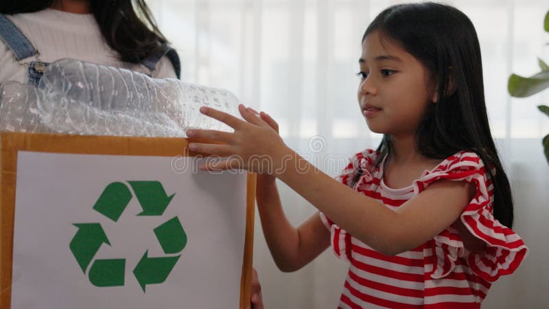 Asian little Girls dump plastic bottles in recycling boxes to reduce trash, reuse, and recycle. Recyclability and sustainability royalty free stock photo