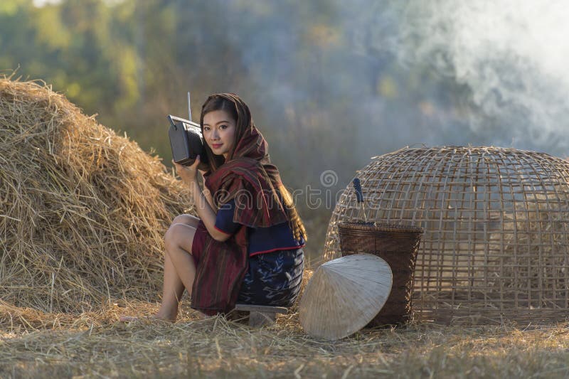 Femeie frumoasă din Asia ascultând la radio pe paie royalty free stock photos