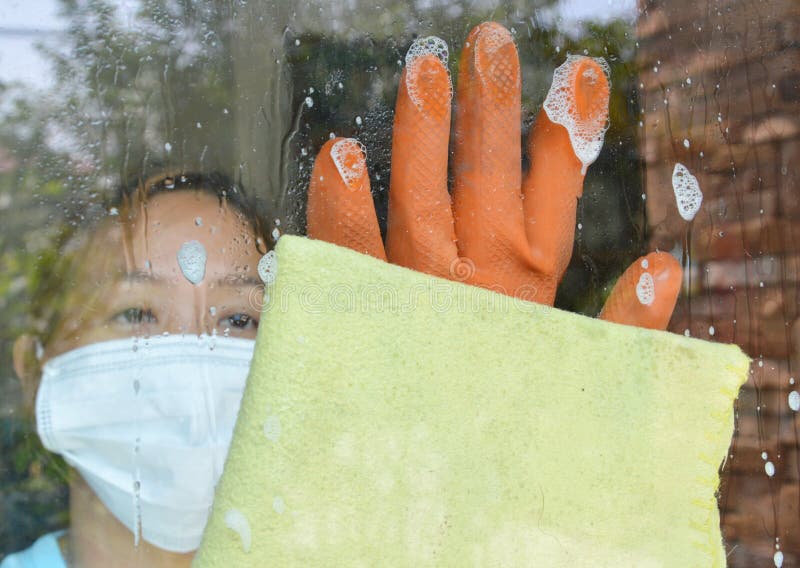Asian maid wipe glass door in home stock photos