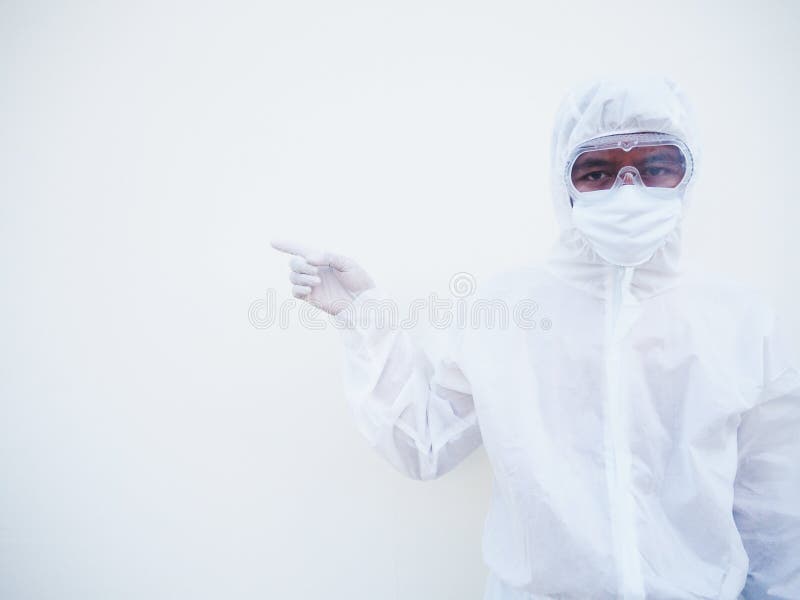 Asian male doctor or scientist in PPE suite uniform showing pointing fingers away at copy space while standing and looking forward royalty free stock image