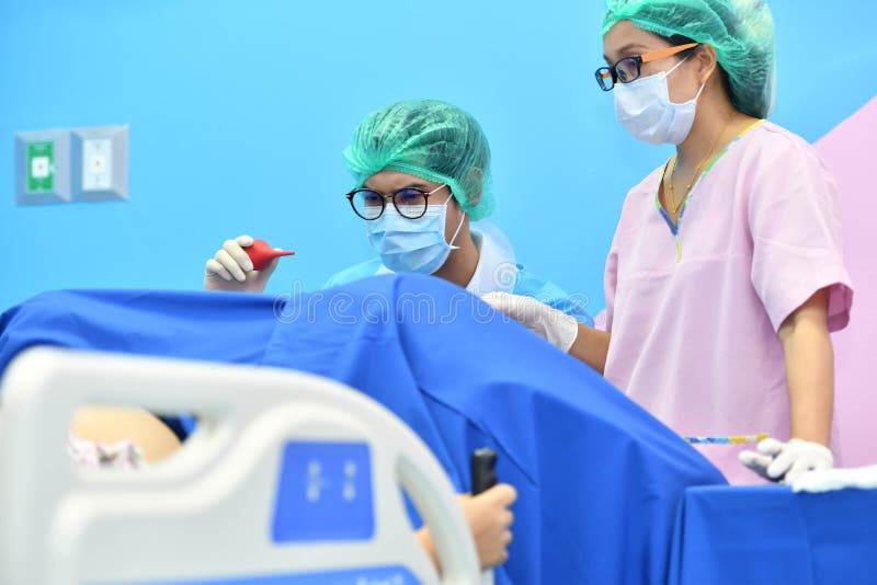 Asian male obstetrician and nurse are delivered to the patient stock photography Asian male obstetrician and nurse are delivered to the patient stock photography