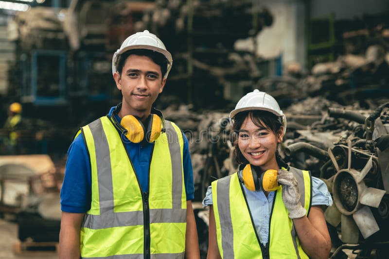 Asian male and woman worker happy working together in heavy industry factory royalty free stock photo