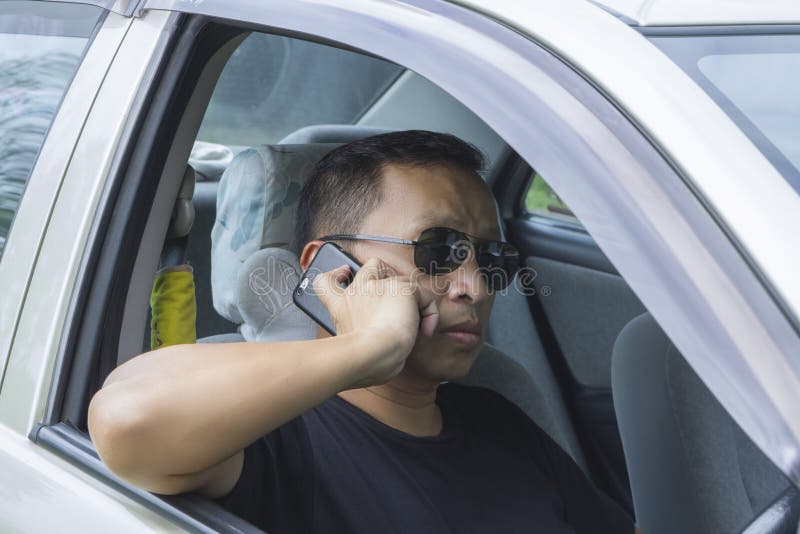 Asian Man in Black Shirt in Sunglass Using Smartphone Stock Photo