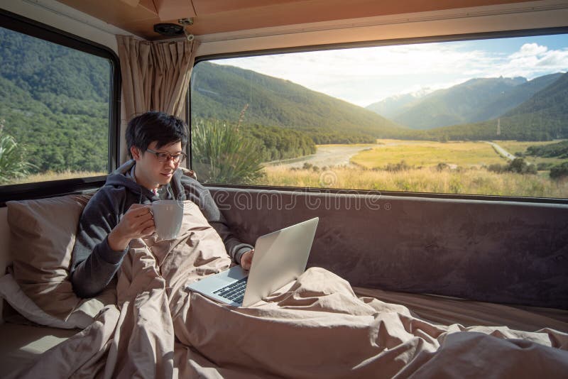 Asian man drinking coffee in camper van royalty free stock image