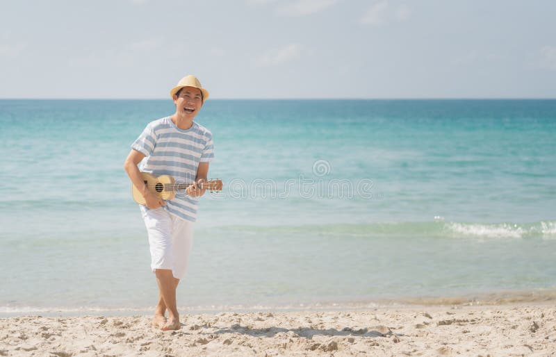Asian man playing a ukulele and singing with enjoy on a tropical beach, Live life happily on holidays