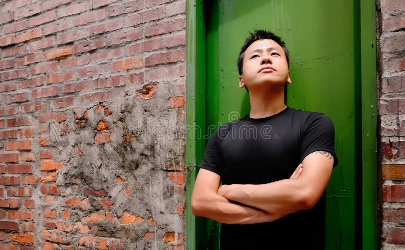 Asian man stand against a old door and lonely