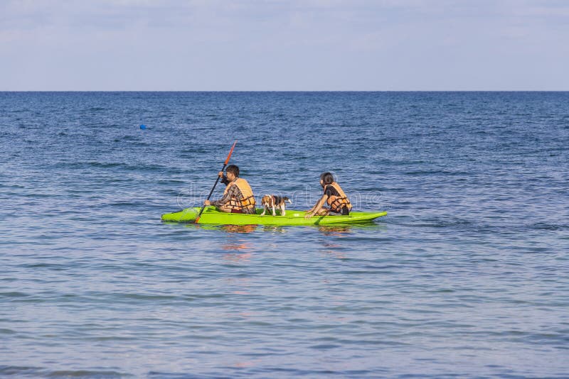 Asian man and woman with his dog in a kayak swims on the sea near island Koh Samet, Thailand. Koh Samet, Thailand - may 08, 2017 : Asian man and woman with his royalty free stock photos