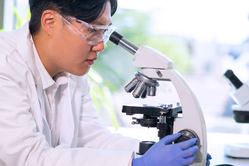 Asian medical doctor working in research lab. Science assistant making pharmaceutical experiments. Chemistry, medicine