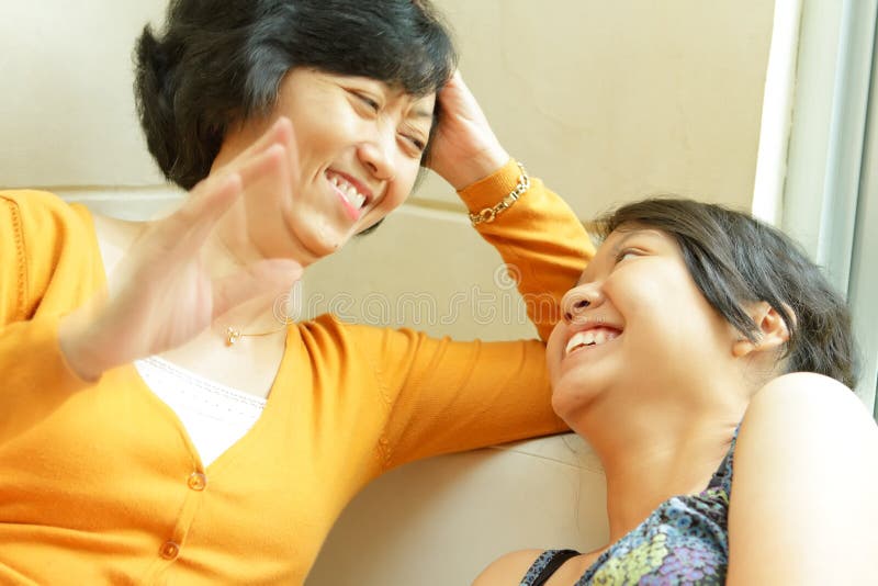 Asian mother happy talking with teen daughter