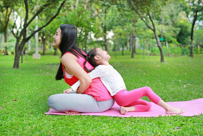 Asian Mother And Her Daughter Doing Exercise In The Public