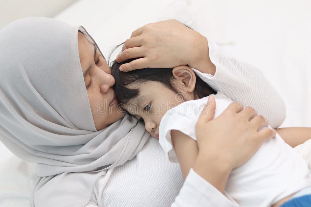 Asian Muslim Mother Wearing Hijab Calming Her Sad Crying Daughter 