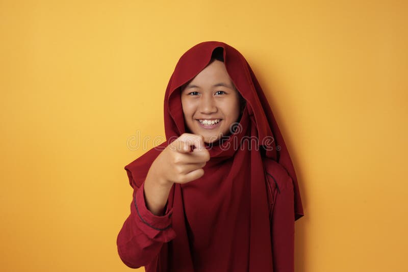 Asian Muslim Teenage Girl Wearing Hijab Smiling and Pointing at Camera royalty free stock image Asian Muslim Teenage Girl Wearing Hijab Smiling and Pointing at Camera royalty free stock image