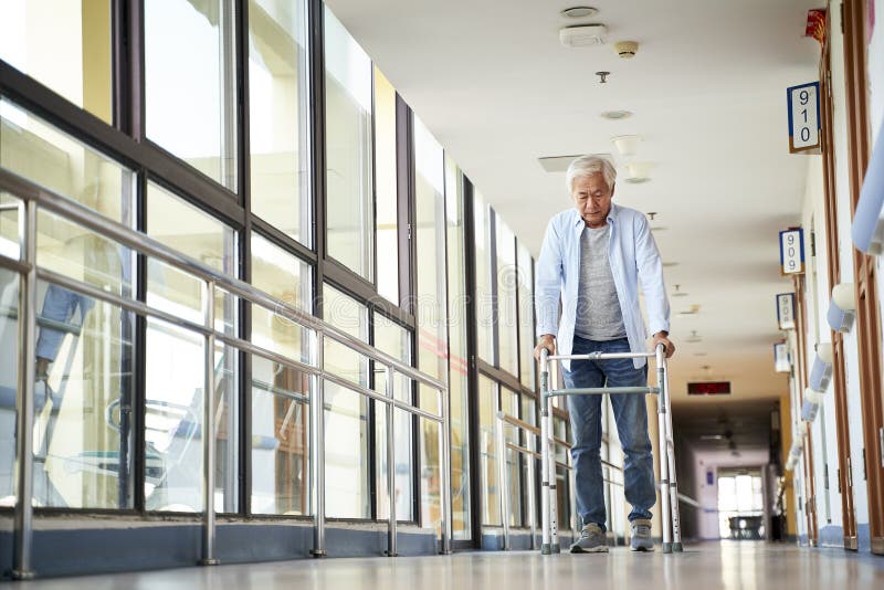 Asian old man walking with a walker in nursing home