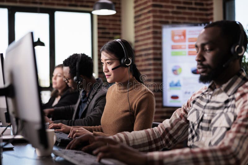 Asian operator working as sales assistant at call center service stock photography