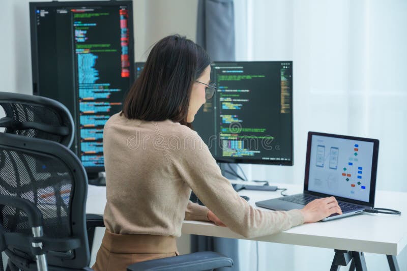 Asian prompt engineer develop coding app with software data sitting in front of computer monitor at office royalty free stock photography