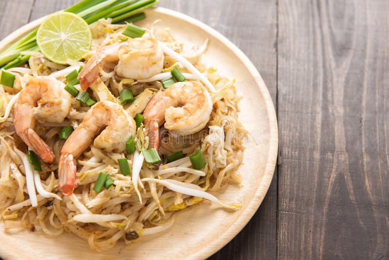 Asian Rice Noodles with Shrimp and Vegetables on Wooden Table. Stock