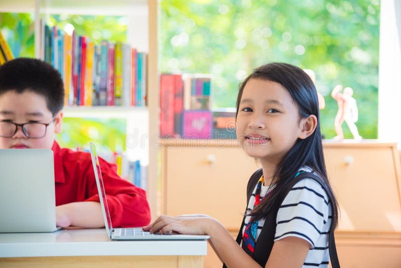 Schoolgirl using laptop computer in library. Asian schoolgirl using laptop computer in school library