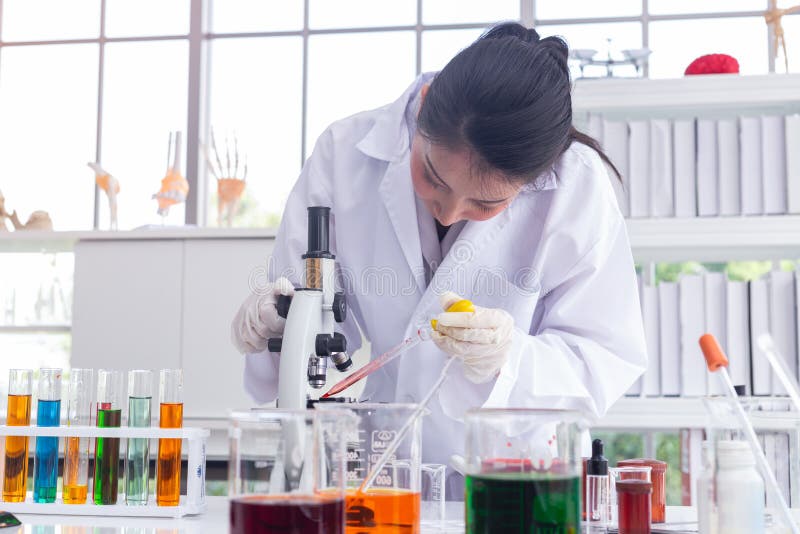 Asian scientists dripping chemicals for the microscope in the laboratory to perform some research stock images