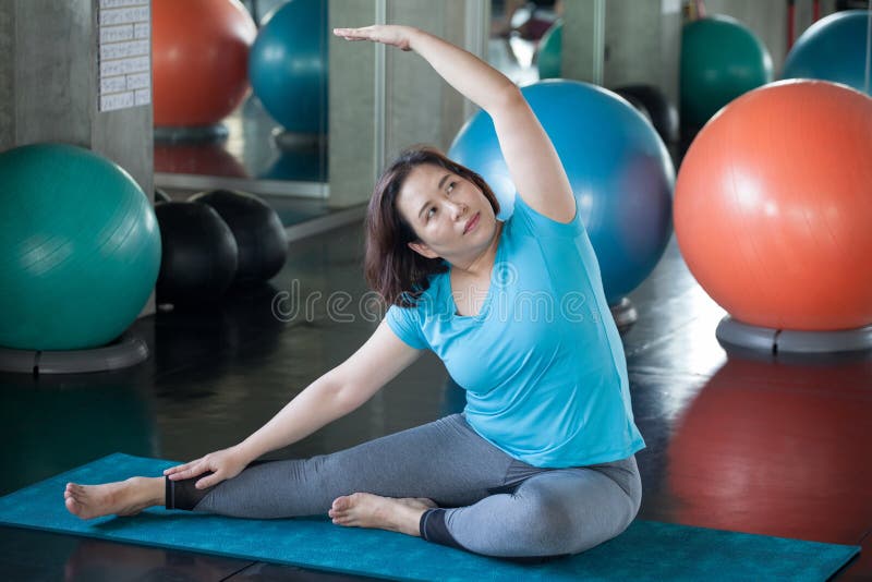 asian Senior woman Doing yoga in fitness gym. aged lady exercising.  Old female workout .Mature fat sport training.rehabilitation.elderly Overweight Healthy lifestyle Weight loss concept, retirement, pensioner, retired, retiree, active, adult, ball, body, care, citizen, class, club, energy, exercise, flexible, focused, happy, holding, meditation, older, people, person, pilates, recreation, strength, stretching, trainer, wellness