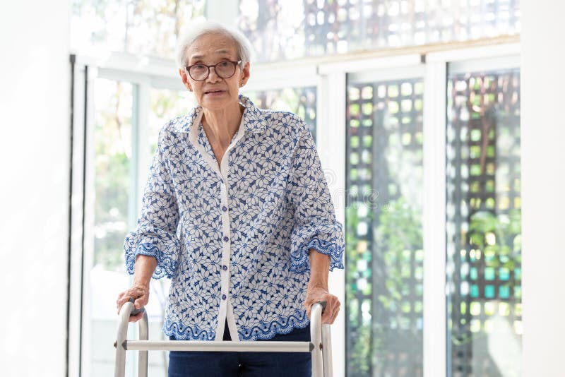 Asian senior woman using walker during rehabilitation, elderly woman with walking and exercising at home