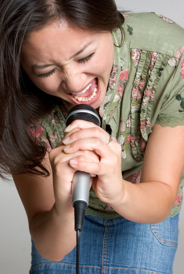 Asian singer singing into microphone