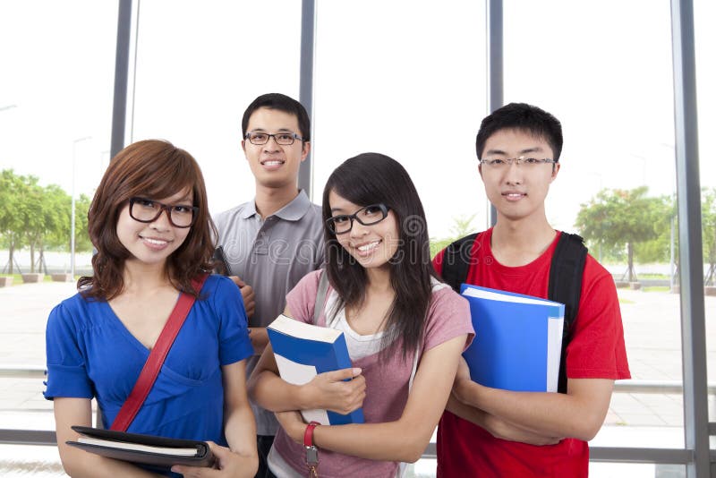 Asian smiling students stand in the classroom stock images
