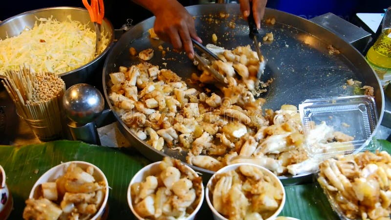 Chef cooking stir-fried squid eggs for sale, Thailand.