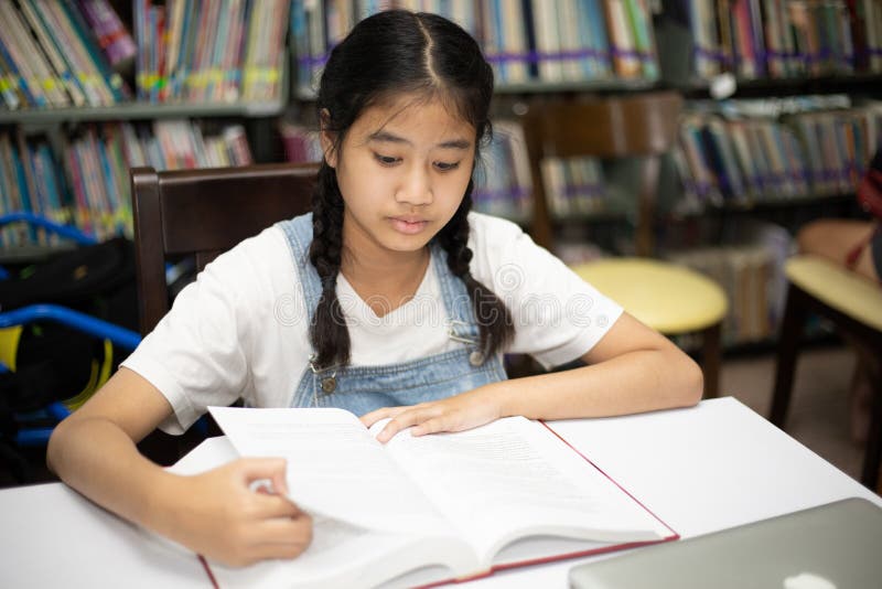 Asian students reading books in the library. royalty free stock image