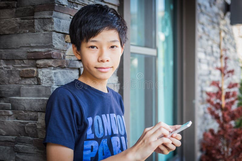 Asian teenage boy using smartphone, communication technology. 