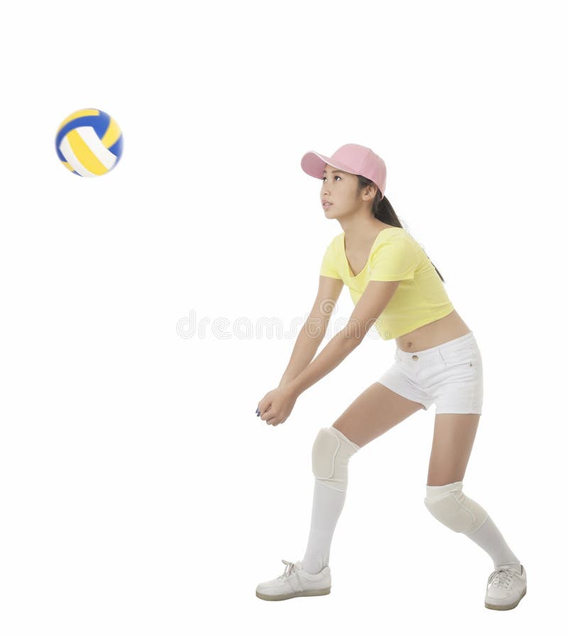 Asian teenage girl hitting a volleyball isolated on white background