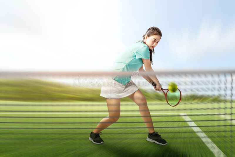 Asian tennis player woman with a tennis racket in her hands hit the ball royalty free stock image Asian tennis player woman with a tennis racket in her hands hit the ball royalty free stock image