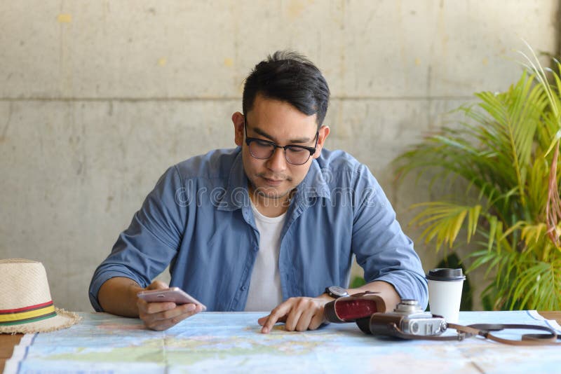 Asian tourist looking at worldmap and plans royalty free stock photography