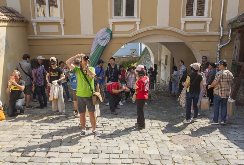 Asian tourists taking photos in Sighisoara medieval town, Romania royalty free stock photography Asian tourists taking photos in Sighisoara medieval town, Romania royalty free stock photography