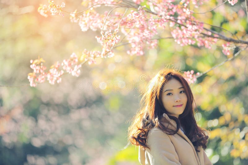 Asian Woman with cherry blossom nature background.