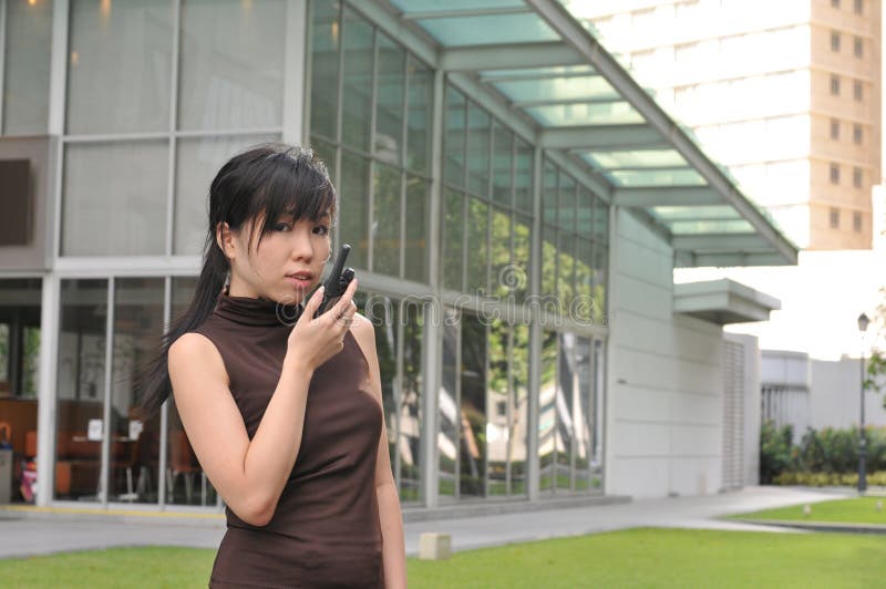 Asian Woman In The City using a walkie talkie