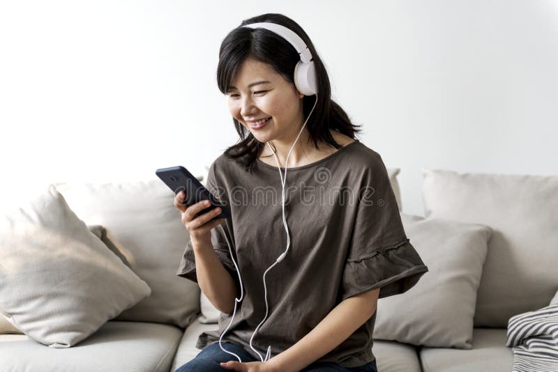 Asian woman enjoying music at home