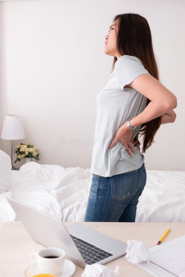 Asian woman freelancer back pain from long time working at home.