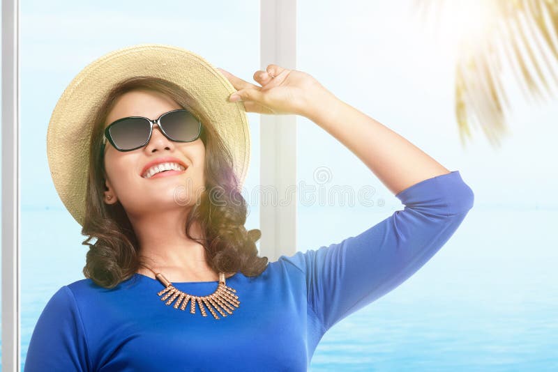 Asian woman with hat and sunglasses standing on the resort stock photo Asian woman with hat and sunglasses standing on the resort stock photo