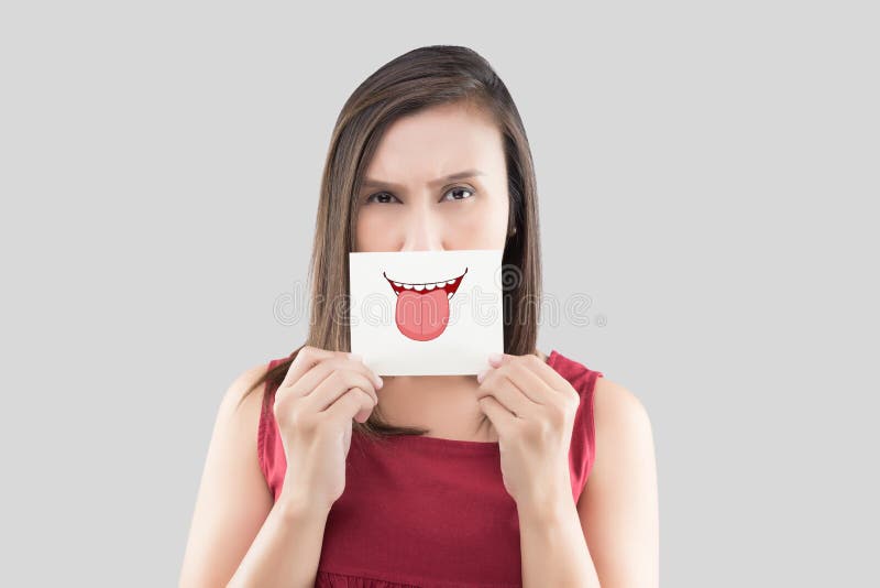 Asian woman holding a paper with a cute tongue face on it in front of her mouth stock image Asian woman holding a paper with a cute tongue face on it in front of her mouth stock image
