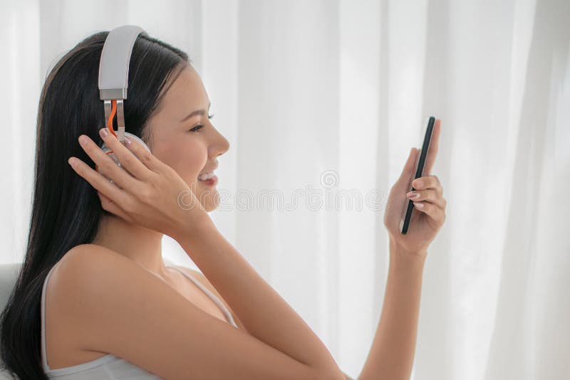 Asian woman listen to music with headset and using smartphone royalty free stock image Asian woman listen to music with headset and using smartphone royalty free stock image
