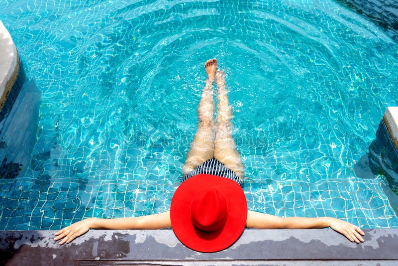 Asian woman with red hat relax on swimming pool