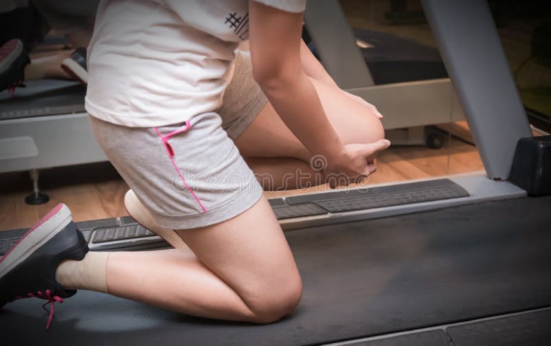 Asian woman runner got sports injury on machine treadmill at fitness gym, Healthy concept