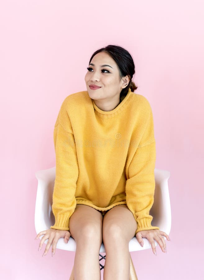 Asian woman sitting on white chair with pink background royalty free stock photos Asian woman sitting on white chair with pink background royalty free stock photos