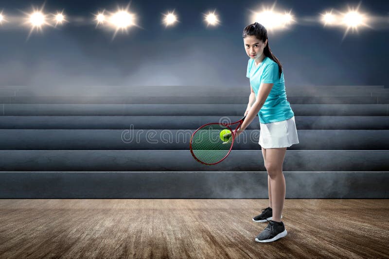 Asian woman with a tennis racket and ball in her hands ready in serve position royalty free stock images Asian woman with a tennis racket and ball in her hands ready in serve position royalty free stock images