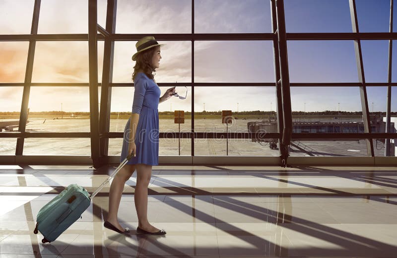 Asian woman travel alone carry suitcase in the airport