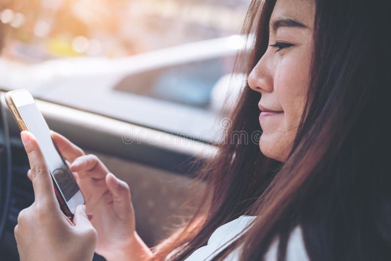 An Asian woman using and looking at smart phone in a car royalty free stock photos An Asian woman using and looking at smart phone in a car royalty free stock photos