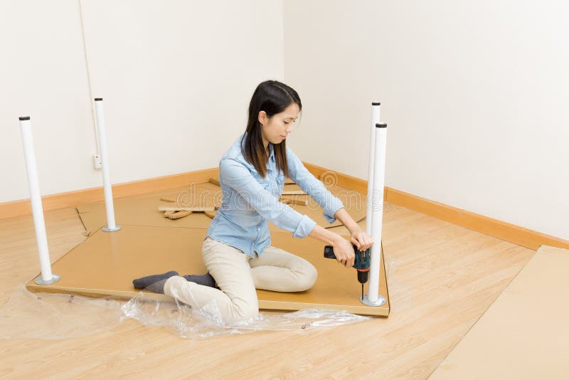 Asian woman using screwdriver for assembling furniture stock images