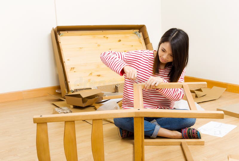 Asian woman using strew driver for assembling furniture stock images