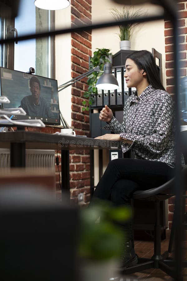 Asian woman on videocall with black man stock photo